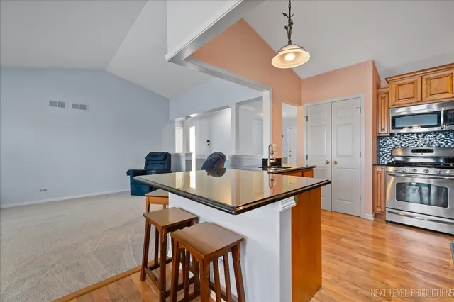 a kitchen with stainless steel appliances granite countertop a sink a stove and a refrigerator