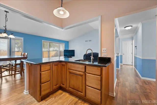 a kitchen with stainless steel appliances granite countertop a sink a stove cabinets and wooden floor