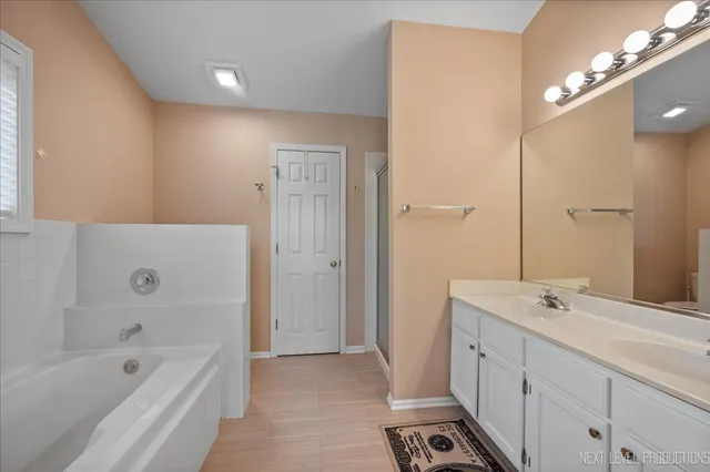 a bathroom with a tub sink and mirror
