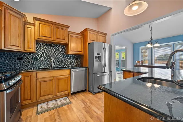 a kitchen with stainless steel appliances granite countertop a refrigerator and a sink
