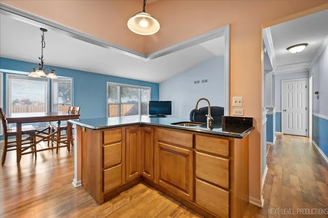 a kitchen with stainless steel appliances granite countertop a sink a stove and wooden floors
