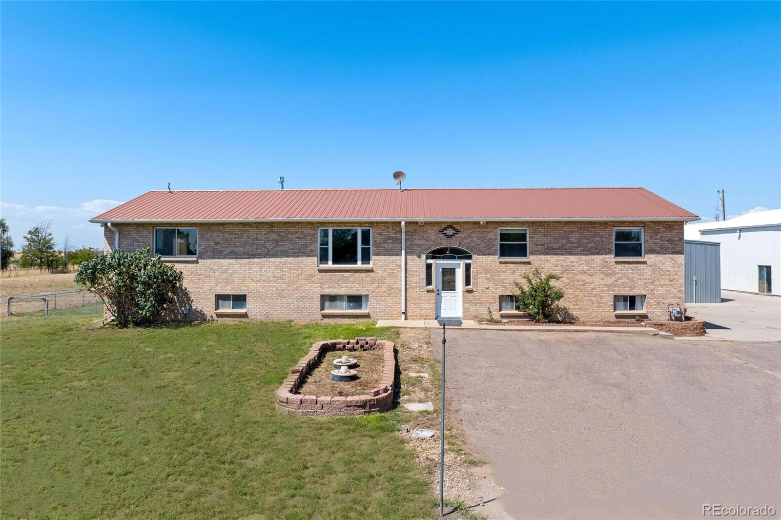 a front view of a house with a garden and yard
