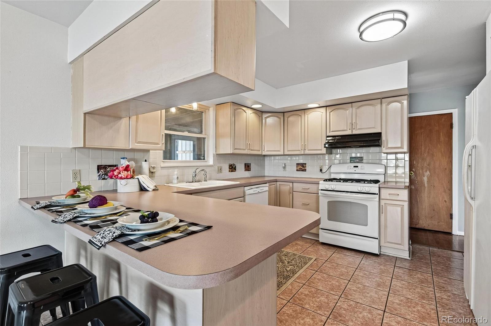 2869 Mathews Avenue Fort Lupton, CO 80621 - Photo 11 of 49 a kitchen with a stove a sink dishwasher and a refrigerator