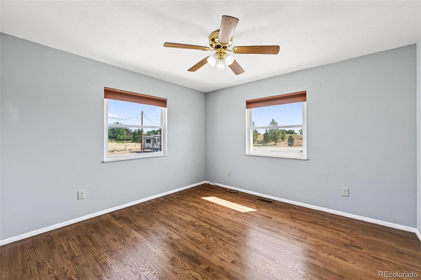 2869 Mathews Avenue Fort Lupton, CO 80621 - Photo 18 of 49 a view of an empty room with wooden floor and a window
