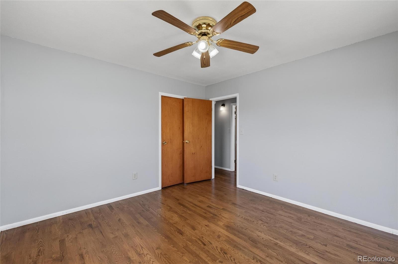 2869 Mathews Avenue Fort Lupton, CO 80621 - Photo 19 of 49 an empty room with wooden floor and ceiling fan