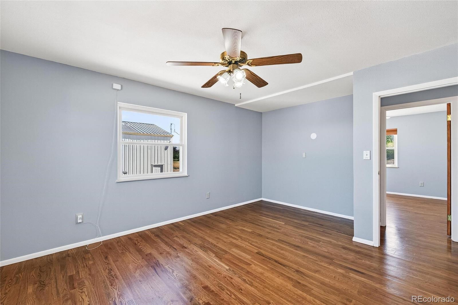 2869 Mathews Avenue Fort Lupton, CO 80621 - Photo 23 of 49 wooden floor in an empty room with a window