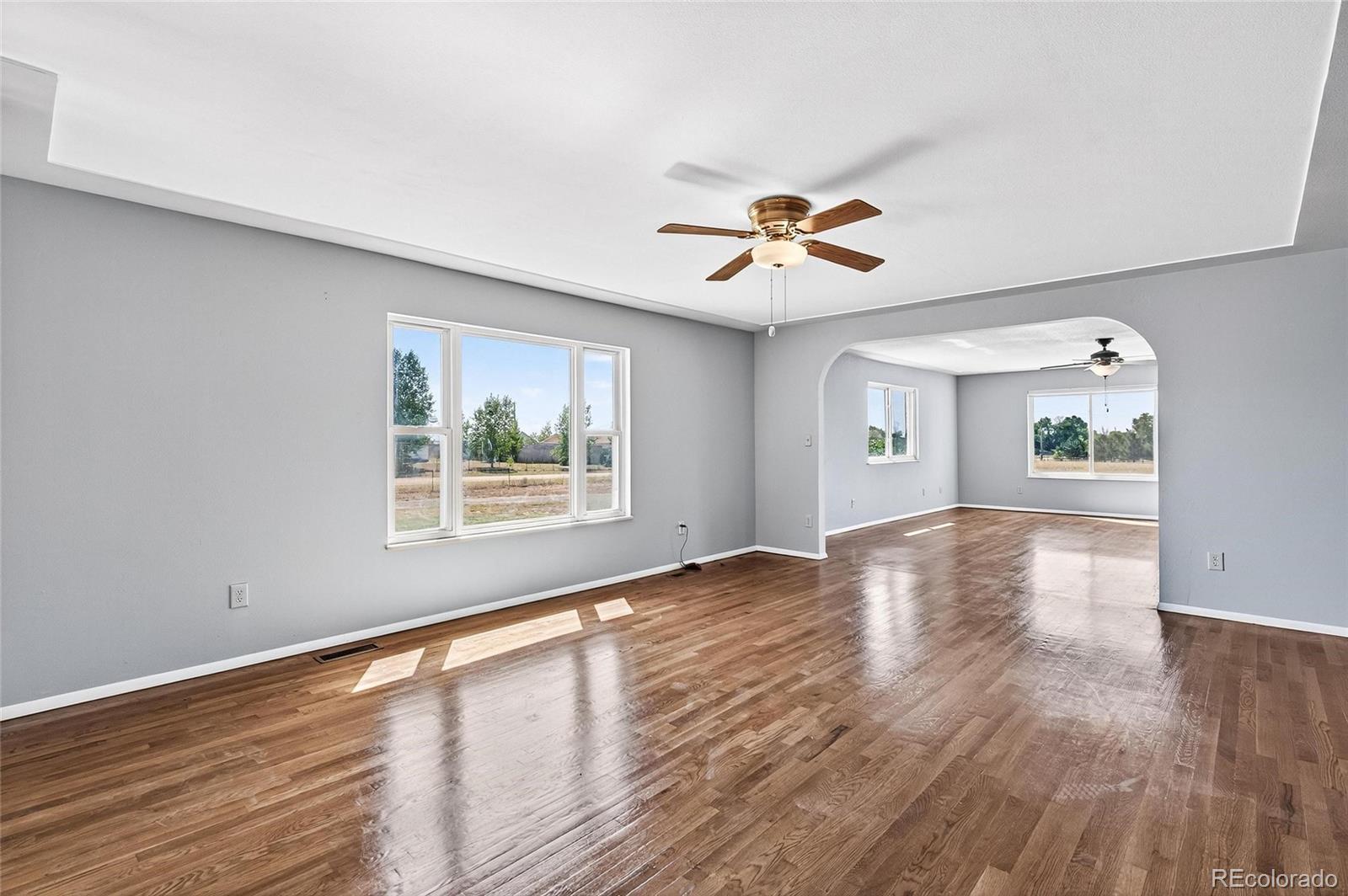 2869 Mathews Avenue Fort Lupton, CO 80621 - Photo 6 of 49 a view of an empty room with a window and wooden floor