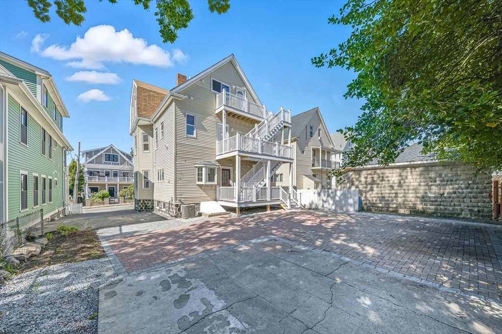 9 Curtis Street, Unit PKG Somerville, MA 02144 - Photo 2 of 2 a view of a large white house next to a yard with large trees
