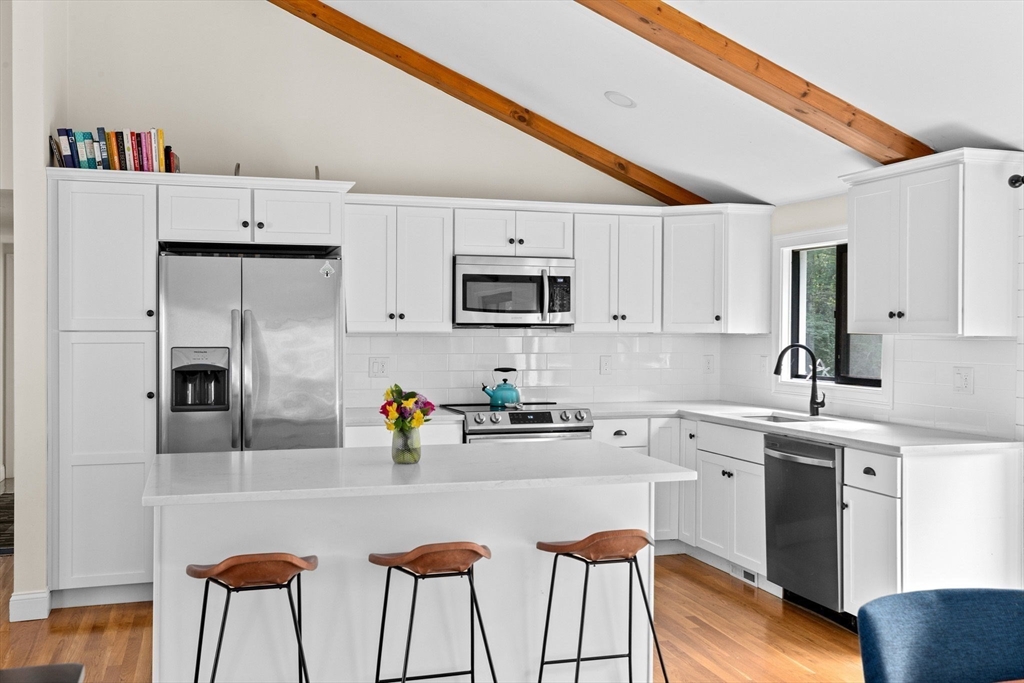 47 Pennfield Road Scituate, MA 02066 - Photo 8 of 27 a kitchen with stainless steel appliances a sink a stove a refrigerator cabinets and dining table