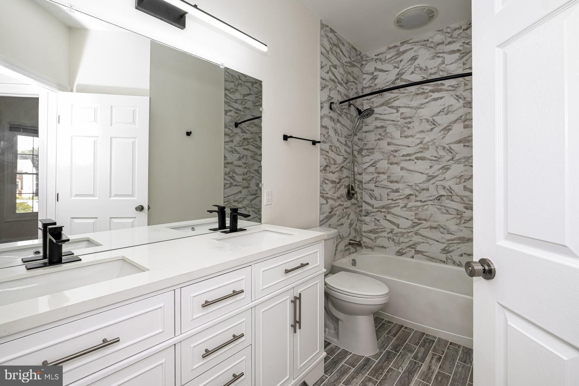 6270 Levi Court Springfield, VA 22150 - Photo 20 of 22 a bathroom with a granite countertop sink a toilet and shower