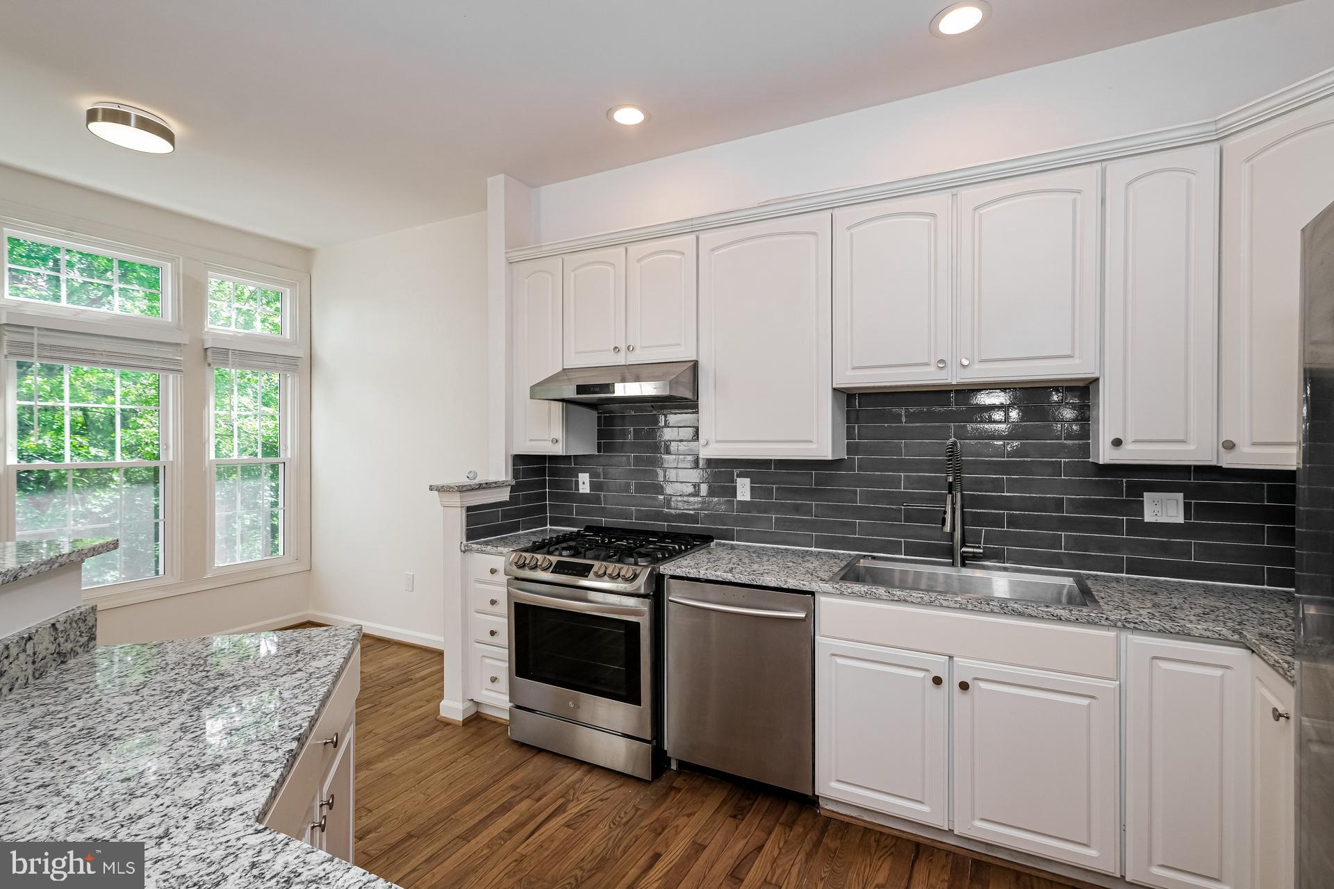 6270 Levi Court Springfield, VA 22150 - Photo 2 of 22 a kitchen with granite countertop white cabinets and appliances