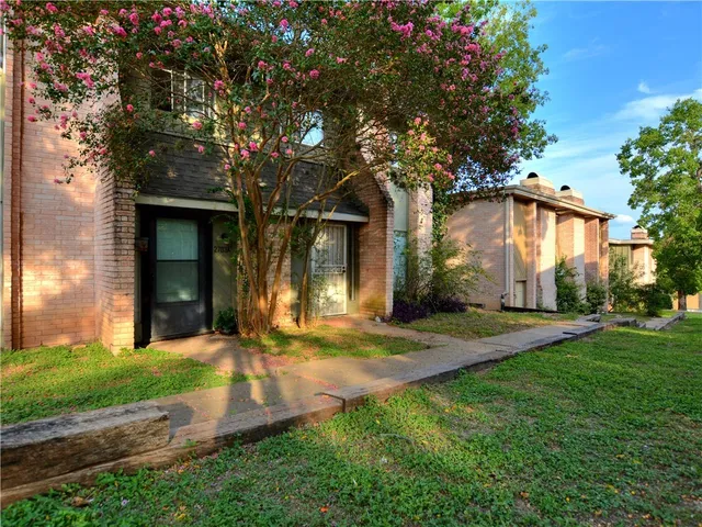 a view of a white house with a big yard and large tree