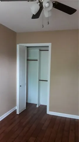 a view of a chandelier fan and window in an empty room