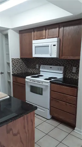 a kitchen with a stove top oven and cabinets