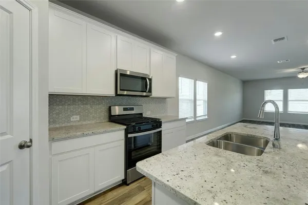a kitchen that has a sink and a stove top oven