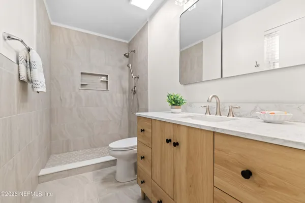 a bathroom with a sink a toilet and shower