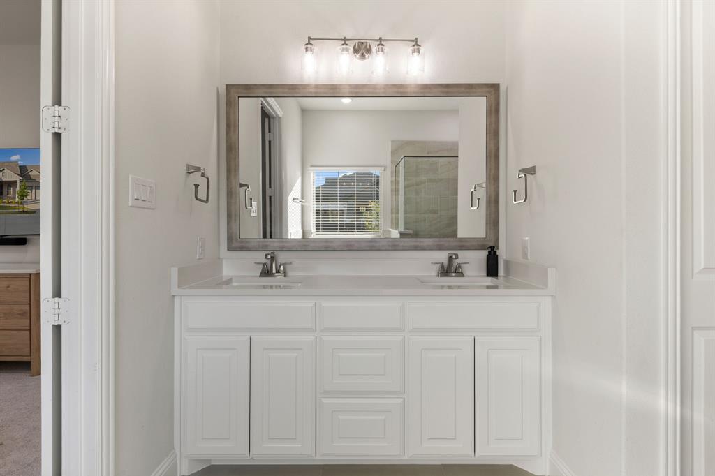 8808 Royal Star Road Rowlett, TX 75089 - Photo 25 of 40 a bathroom with a granite countertop sink and a mirror