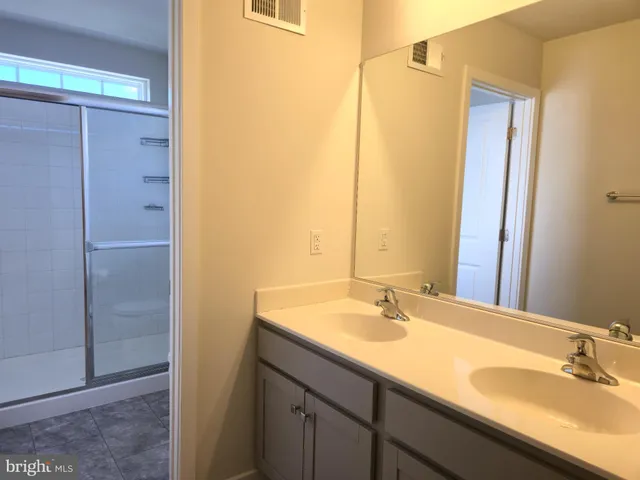 a bathroom with a double vanity sink and a mirror