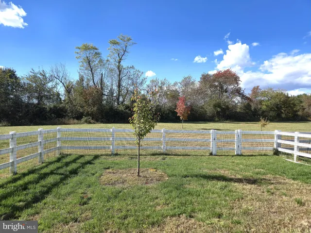 a view of a green field with wooden fence