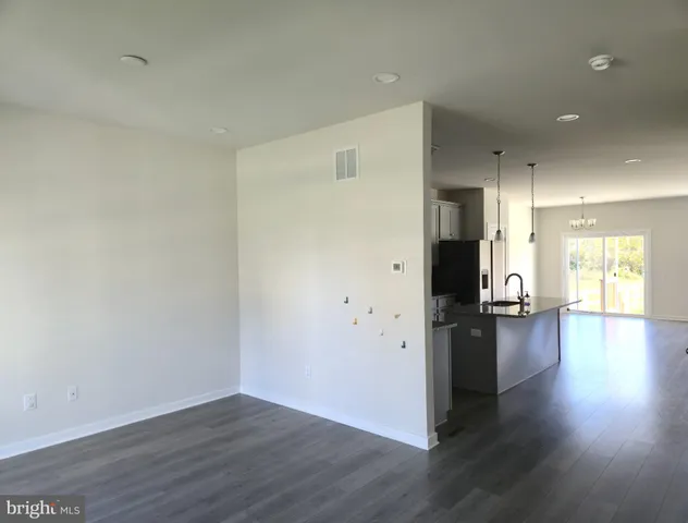 a view of a kitchen with a fridge and wooden floor