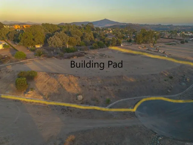 a view of dirt field with ocean view