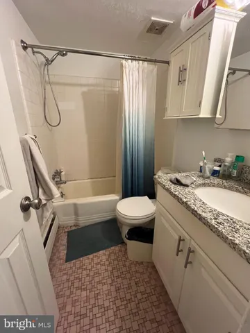 a bathroom with a granite countertop sink toilet and shower