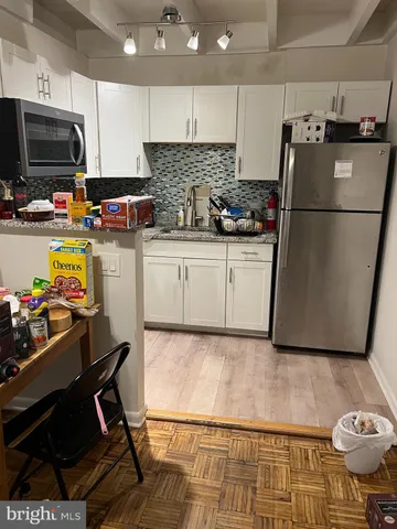 a kitchen with a refrigerator and a stove top oven