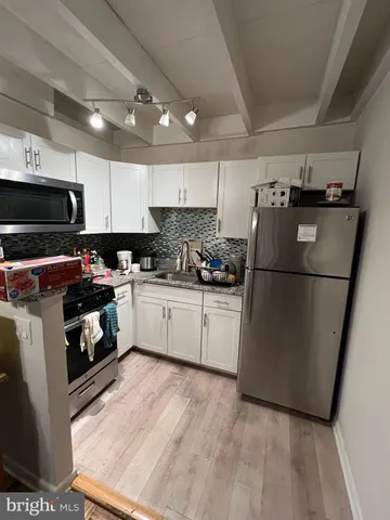 a kitchen with a refrigerator a microwave a sink and a stove