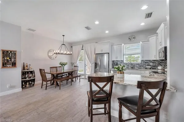 a kitchen with kitchen island a dining table and chairs
