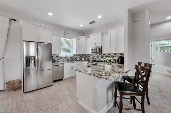a kitchen with white cabinets and stainless steel appliances