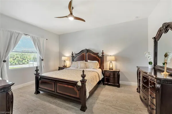 a bedroom with a bed and a flat tv screen on the dresser
