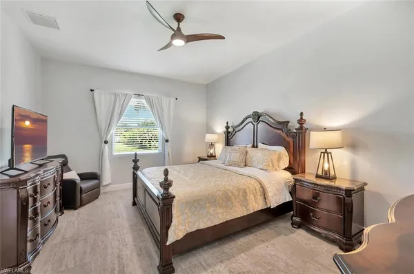 a bedroom with a bed a flat screen tv and a window