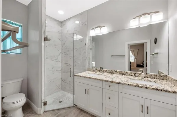 a bathroom with a granite countertop sink toilet and shower