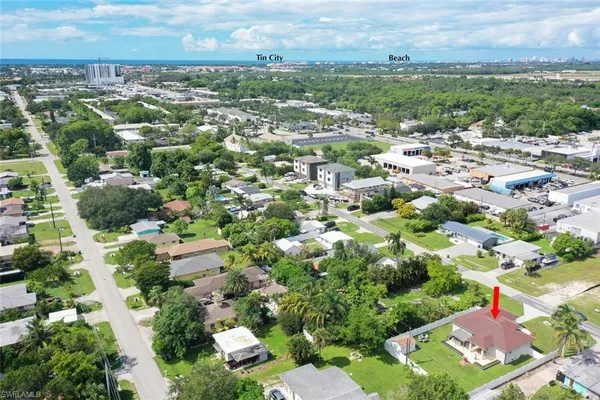 an aerial view of residential houses with outdoor space and trees