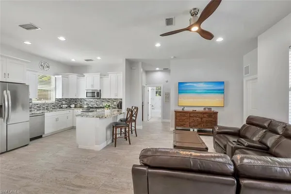 a living room with furniture and kitchen view