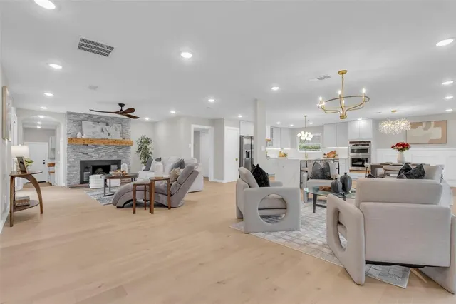 a living room with furniture a fireplace and a view of kitchen