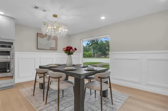 a view of a dining room with furniture a chandelier and wooden floor