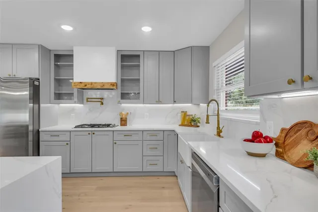 a kitchen with granite countertop a sink stainless steel appliances and cabinets