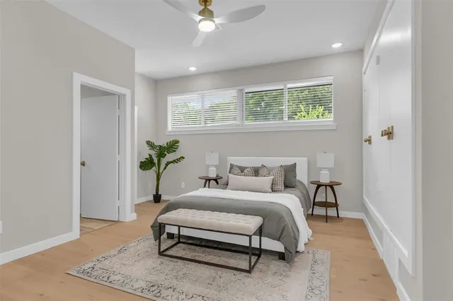 a bedroom with a bed lamp and a potted plant