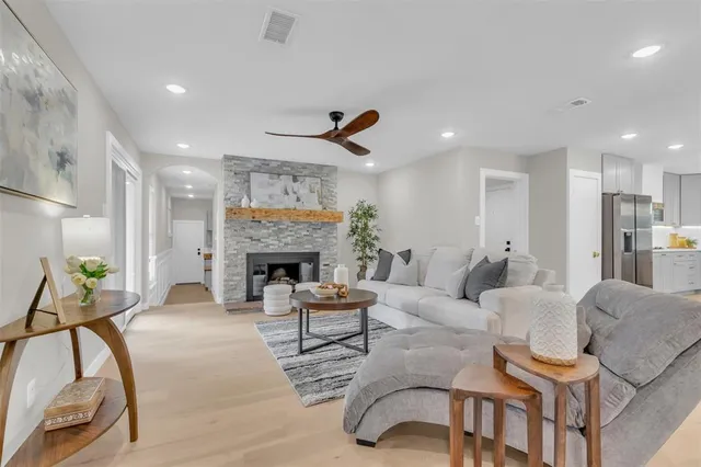 a living room with furniture a fireplace and a chandelier