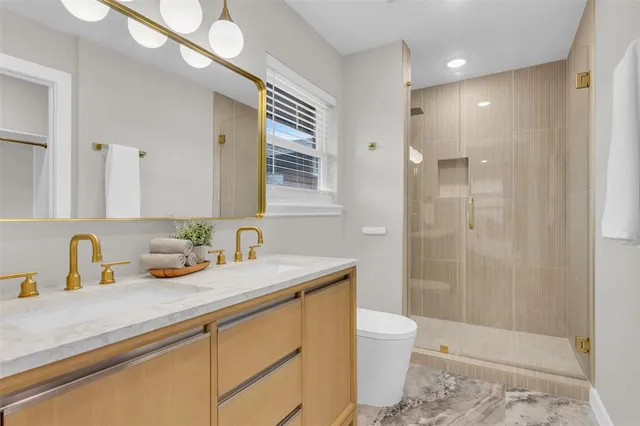 a bathroom with a sink a toilet and shower