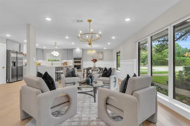 a living room with furniture kitchen view and a large window