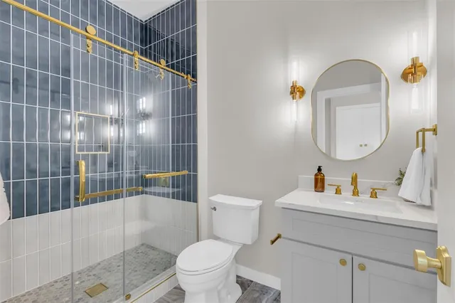 a bathroom with a toilet sink vanity tub and mirror