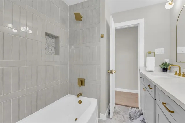 a bathroom with a tub sink and mirror