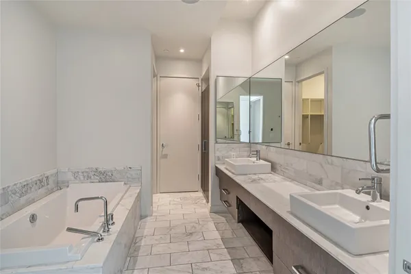a spacious bathroom with a tub sink and mirror