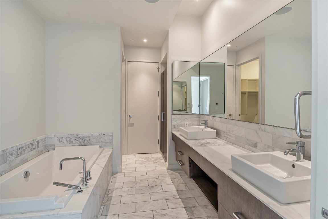 210 Lavaca Street, Unit 2903 Austin, TX 78701 - Photo 12 of 39 a spacious bathroom with a tub sink and mirror