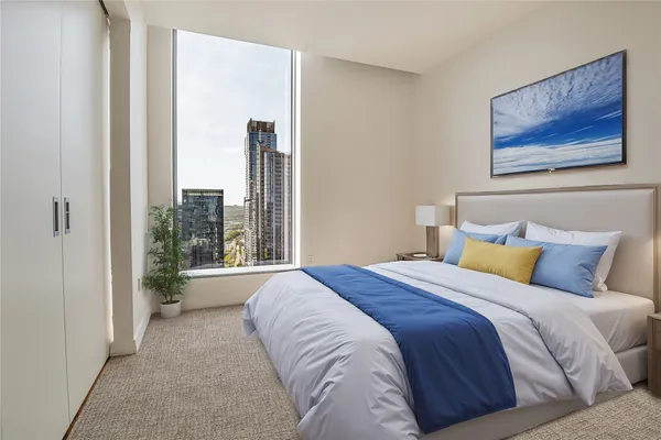 a bedroom with a large bed and a large window