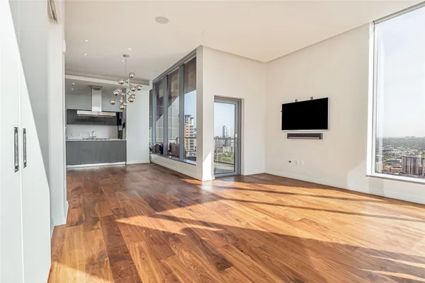 a view of a livingroom with wooden floor and a flat screen tv