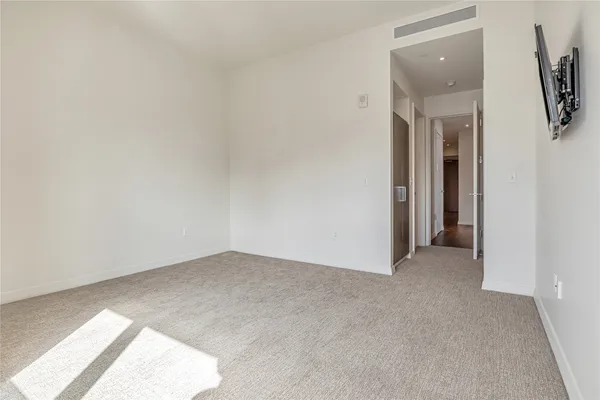 an empty room with a bathroom and mirror