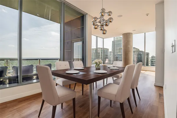 a view of a dining room with furniture large windows and wooden floor